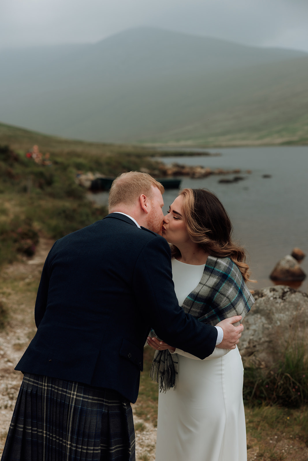 Bride and groom sharing their first kiss during elopement ceremony at Loch Iorsa, Isle of Arran.
