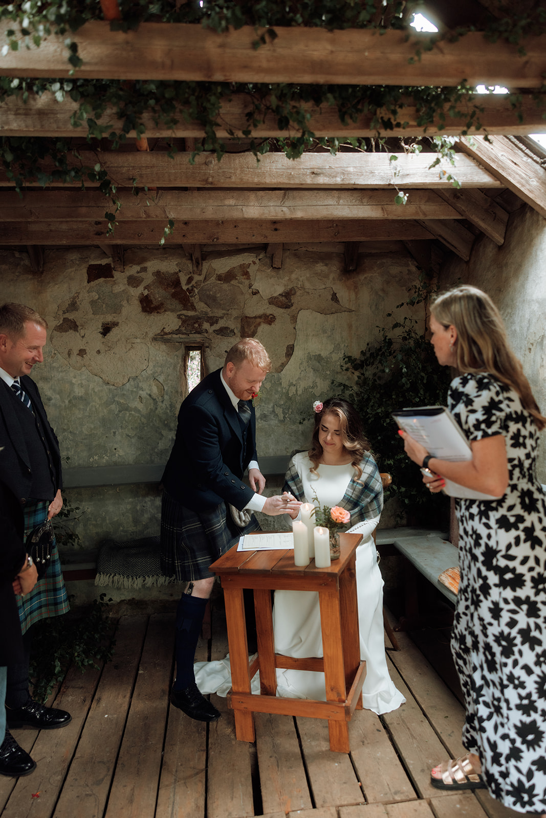 Bride and groom signing marriage paperwork during Isle of Arran elopement ceremony.