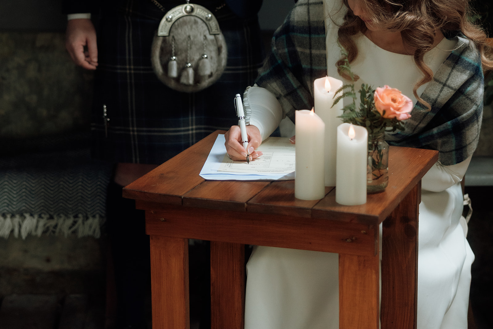 Close-up of bride signing paperwork during Isle of Arran elopement.