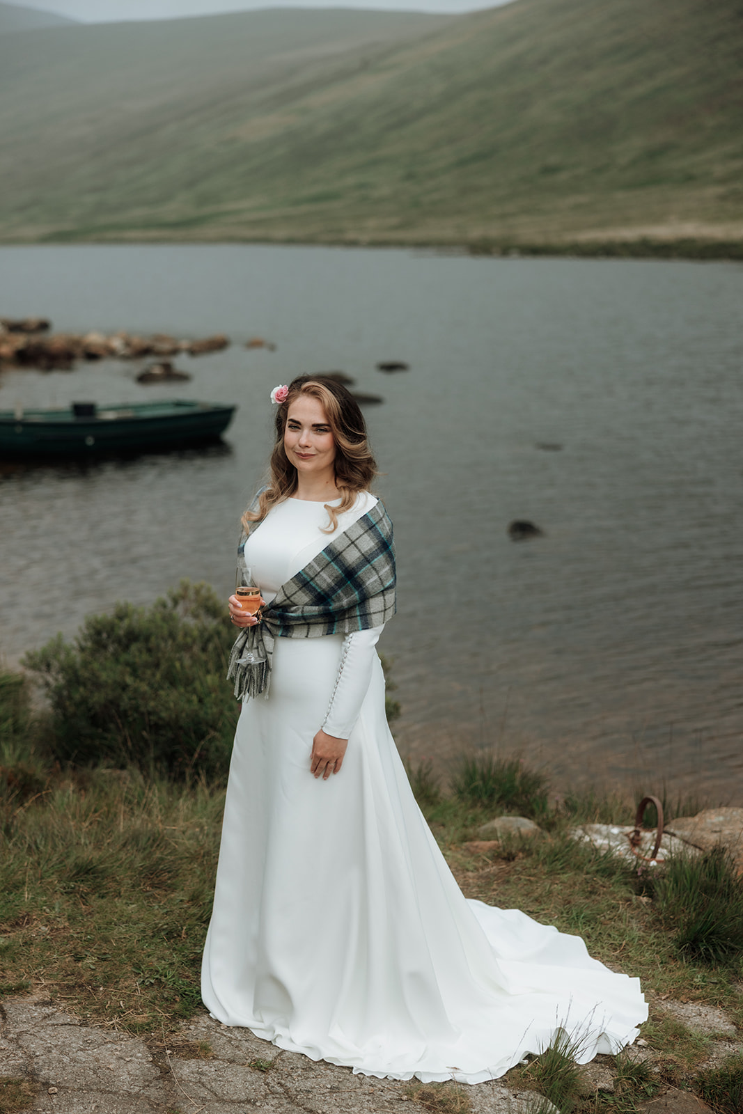 Bride standing alone beside Loch Iorsa during Isle of Arran elopement.