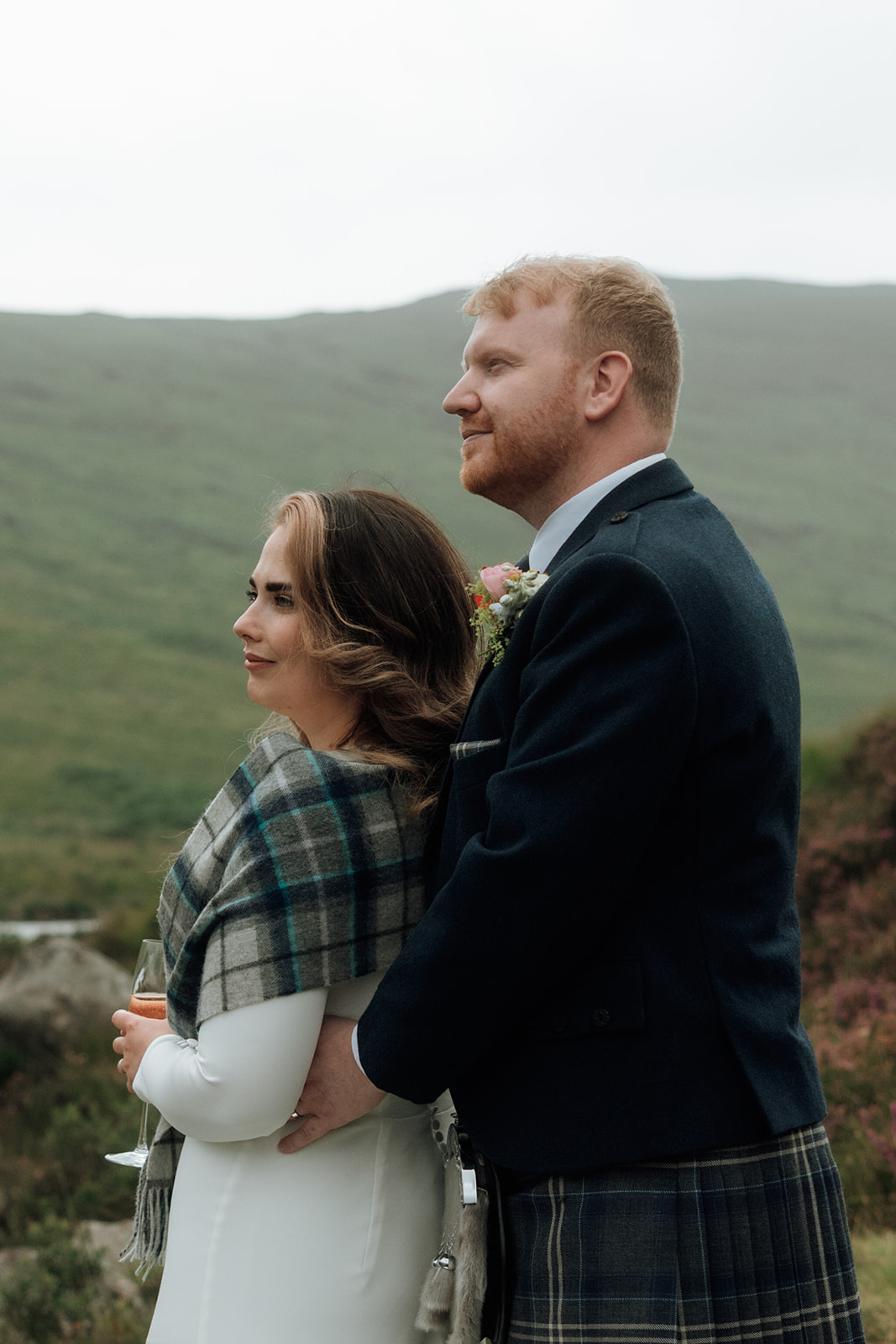 Bride and groom standing together with hills behind during Isle of Arran elopement.