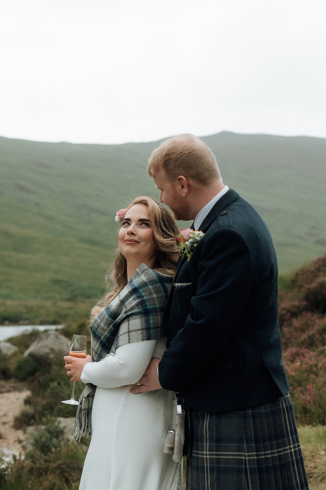 Bride looking to the side while groom stands behind her during Isle of Arran elopement.