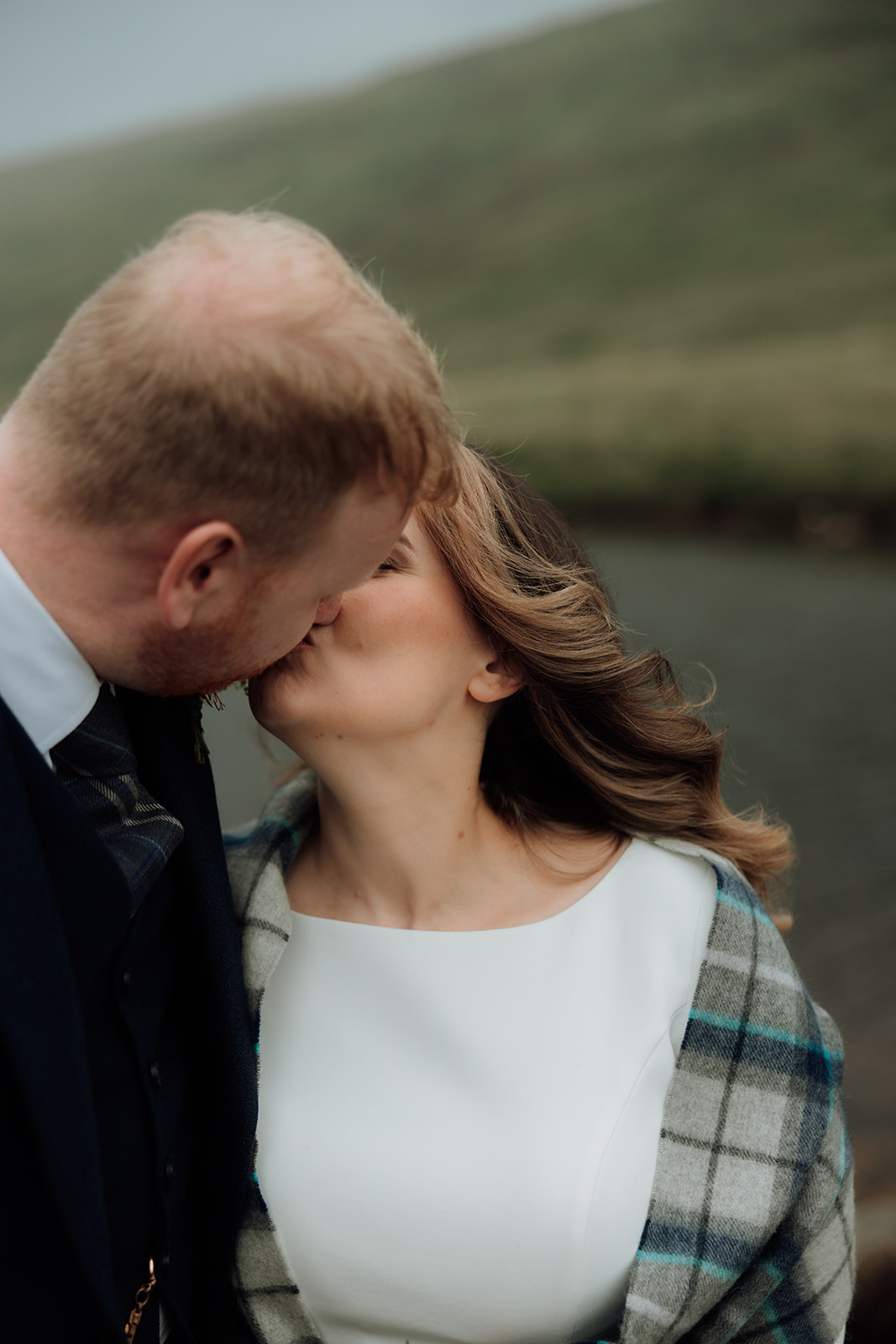Bride and groom kissing outdoors at Loch Iorsa during Isle of Arran elopement.