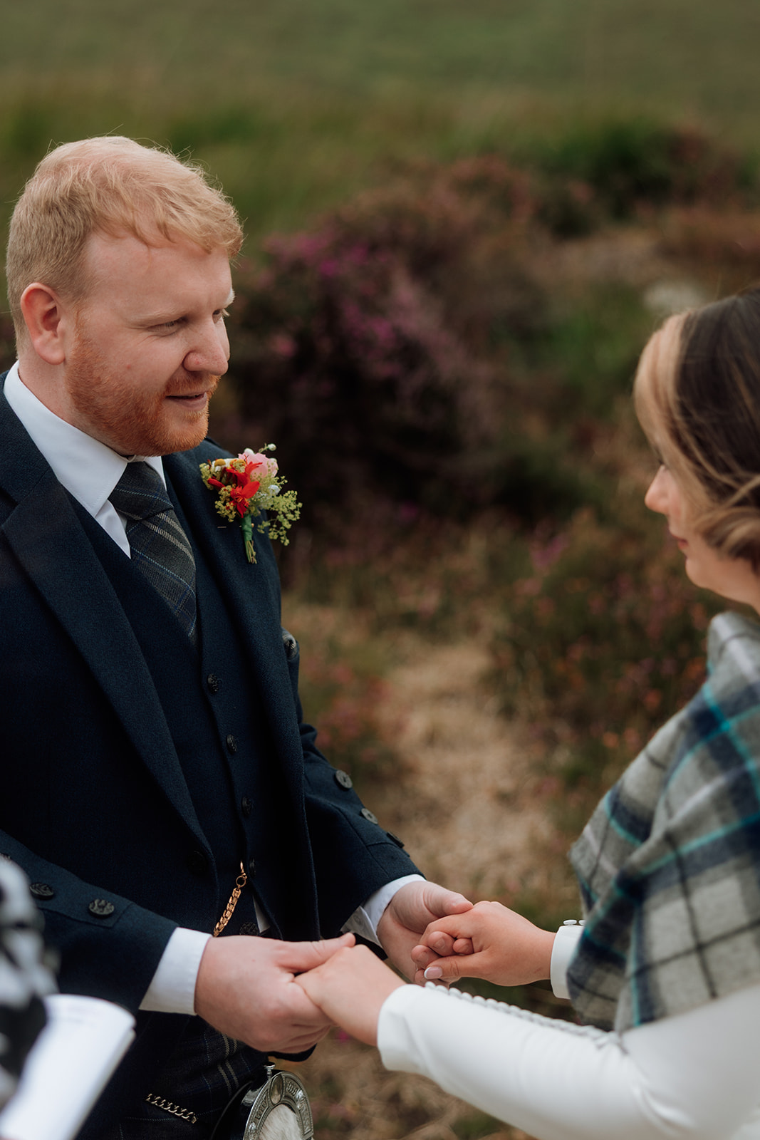 Groom holding bride’s hands during vows at Loch Iorsa, Isle of Arran.