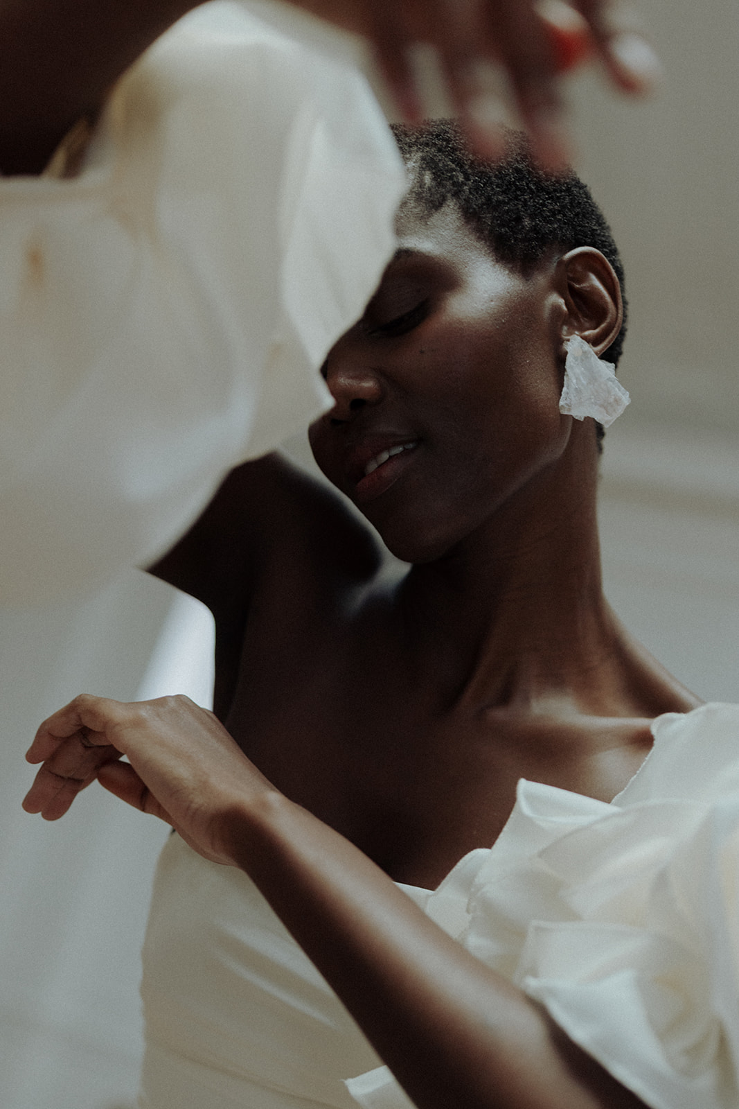 Bride in sculptural Darla Haute Couture gown with statement earrings, editorial bridal close-up.