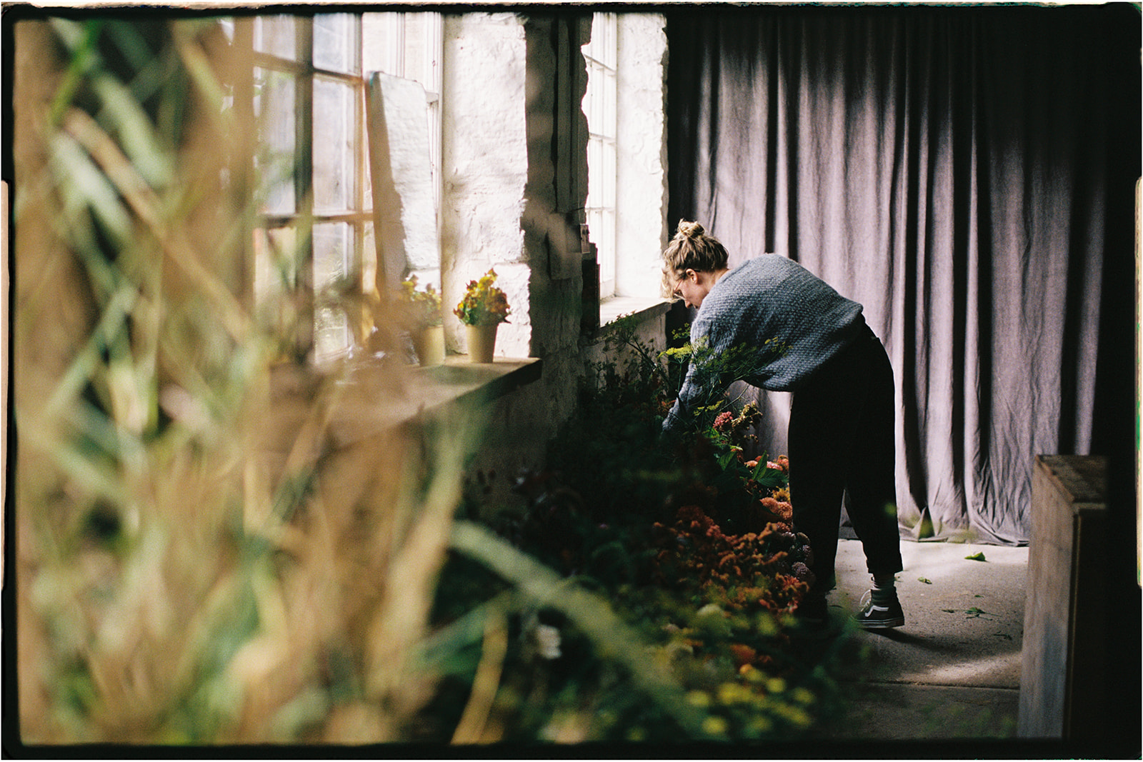 Tupelo Tree florist working on a large-scale floral installation inside the studio.